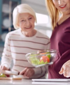 une dame et une personne âgée qui cuisinent ensemble