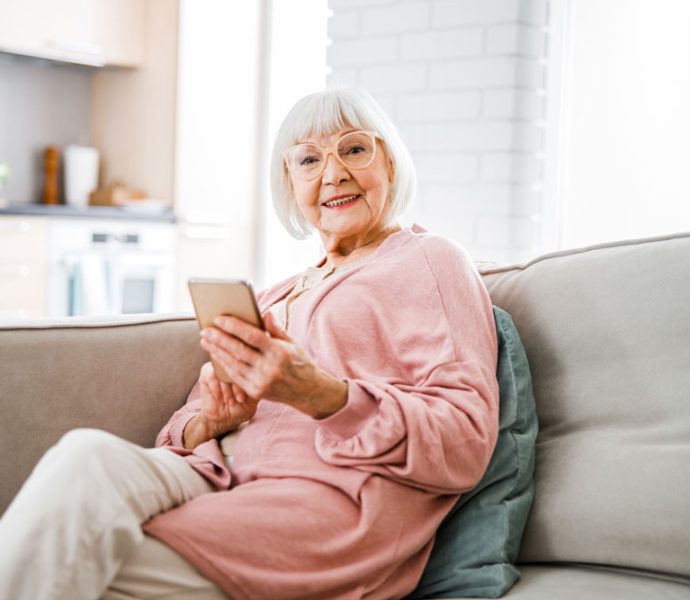 une personne âgée qui consulte son téléphone portable